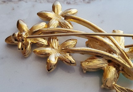 flowers with green enamel, green stones and aurora borealis rhinestones pin back detail